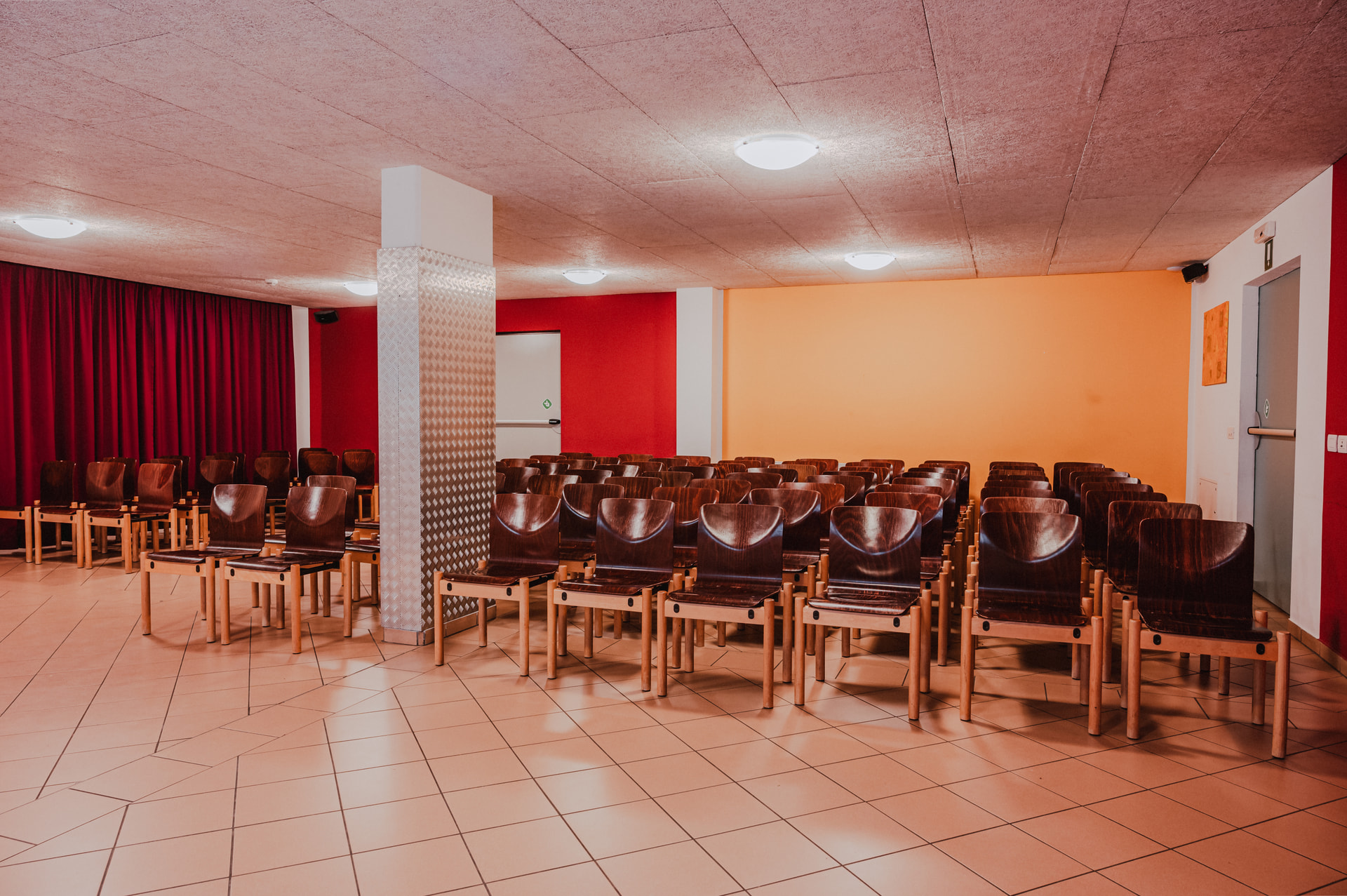 Large multipurpose room with red curtain at the Sonnenhof